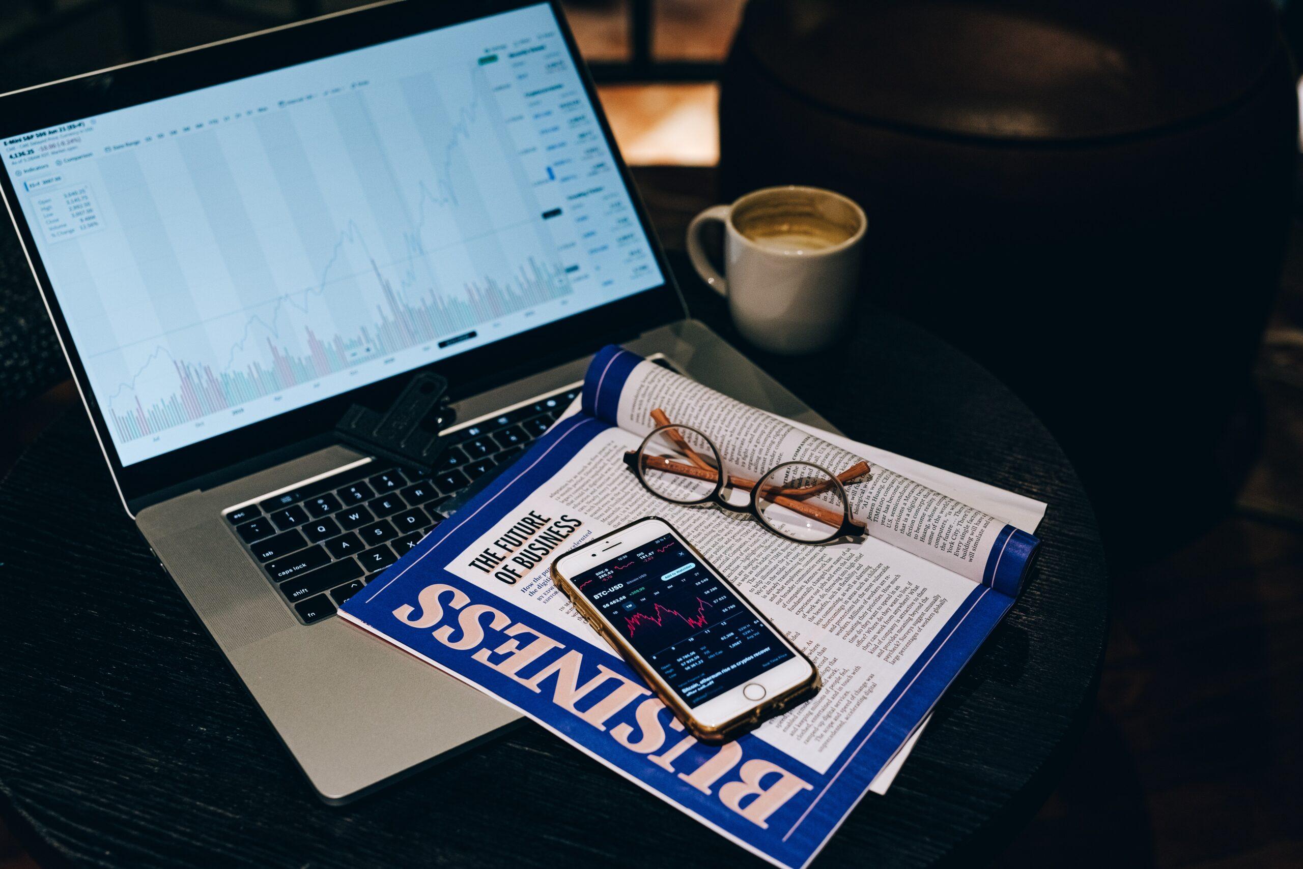 photo of monthly newsletter with Smartphone and Eyeglasses on Laptop